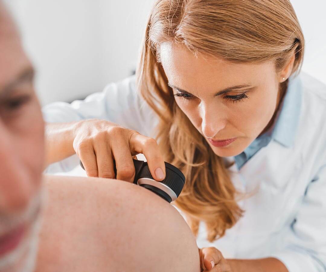 A patient receiving a physical skin cancer check.