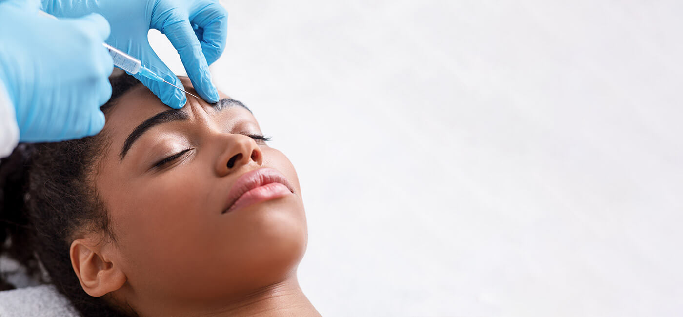 Young woman having botox in her forehead as part of ongoing anti wrinkle injections.